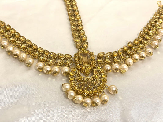 A decorative forehead ornament in bronze, adorned with cultural motifs.