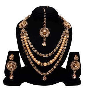 Gold necklace and jhumkas presented on a mould