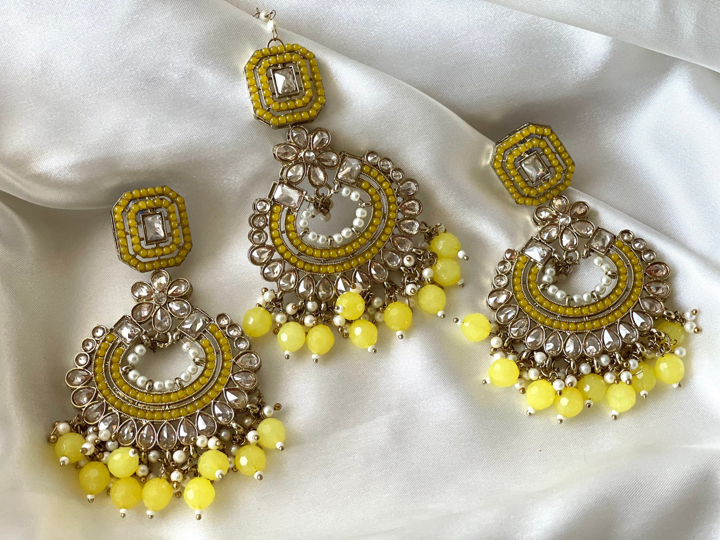 An elegant yellow tikka and earrings